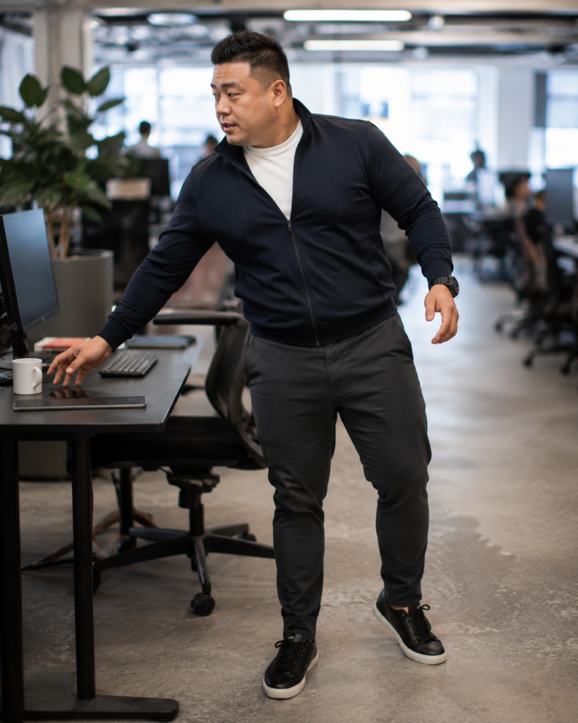 Black Zip-Up Track Jacket Over a White Fitted Long-Sleeve With Dark Grey Jogger Trousers and Black Sneakers