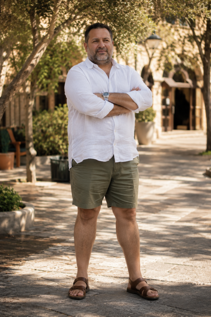 Fitted White Linen Shirt Worn Untucked With Olive Shorts and Clean Brown Leather Sandals for Outdoor Work Settings