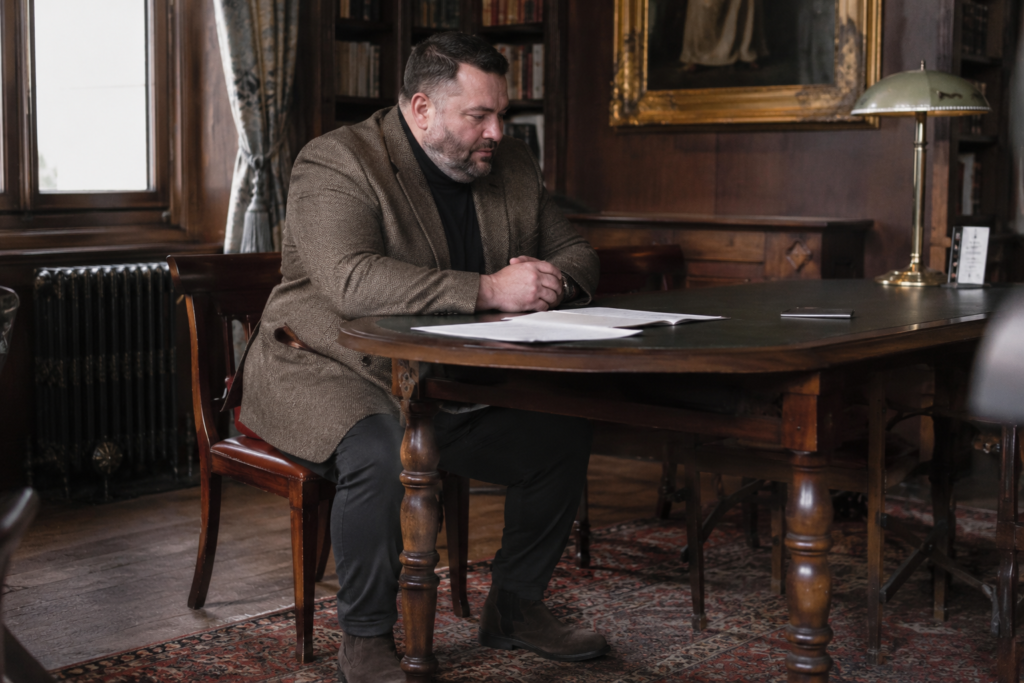 Herringbone Tweed Blazer With Dark Dress Trousers, a Black Mock Neck, and Suede Boots