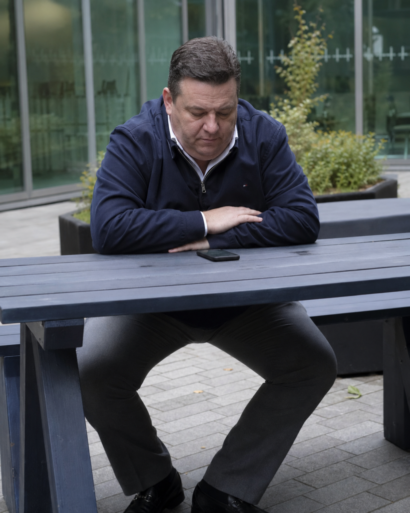 The Navy Zip-Up Blouson Jacket Over a White Shirt and Grey Straight Trouser