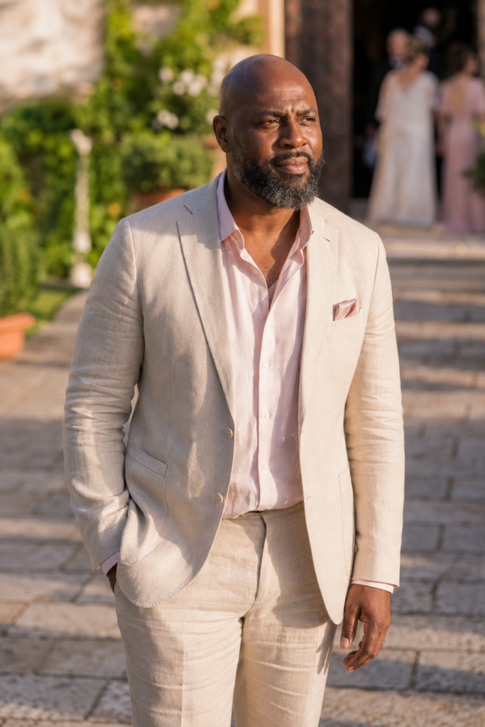 The Stone Linen Suit With a Pale Pink Shirt for a Summer Afternoon Wedding