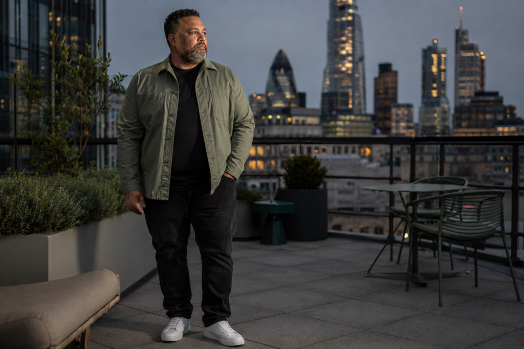 Washed Black Relaxed Jeans With a Sage Green Overshirt and White Low-Profile Trainers