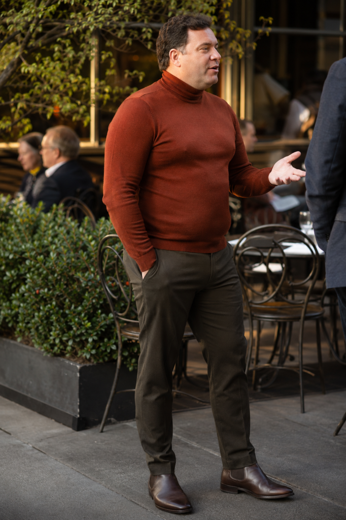Dark Olive Slim Trousers With a Fitted Rust Turtleneck and Dark Brown Chelsea Boots